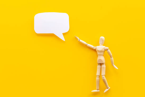 istock Wooden man figure presenting and showing on speech bubble banner 1344742610