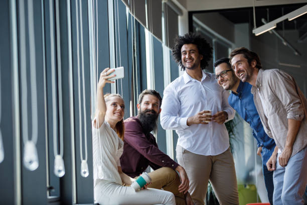 istock Group of business colleagues taking selfies on a coffee break 1344743242
