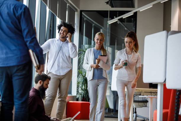 istock Two businesswomen passing by the office corridor, going on a coffee break 1344743252