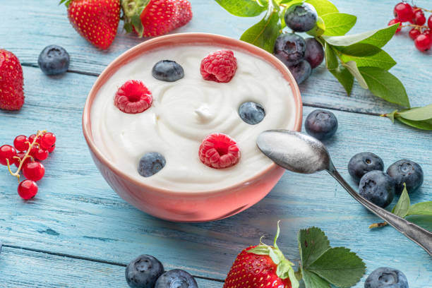 istock Ceramic bowl with plain yoghurt and berries on the table. Light summer mood. 1344744003