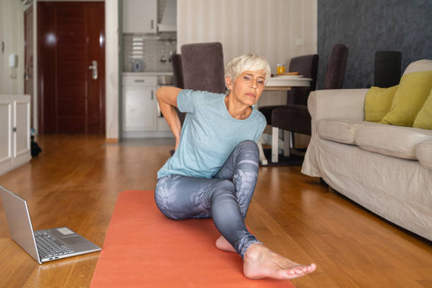 istock With a backache, dedicated senior woman starting with her home workout on order to reduce muscle pain and tension 1344744049