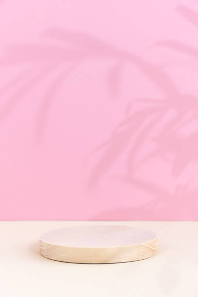 istock A cylindrical wooden scene on a beige table on a pink background. 1344745595