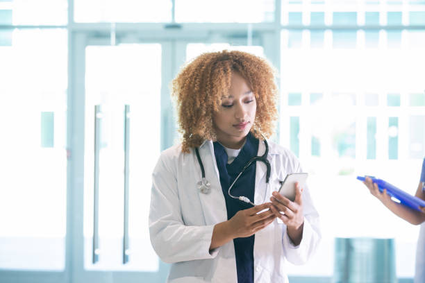 istock Mixed race doctor texting on her cell phone 1344747144