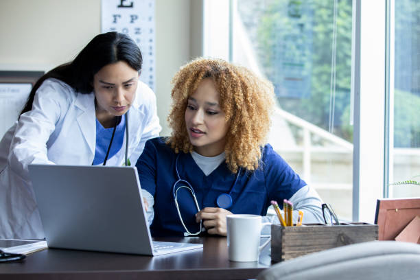 의사와 그녀의 간호사가 대화를 나누고 있습니다. - computer medical student hospital nurse 뉴스 사진 이미지