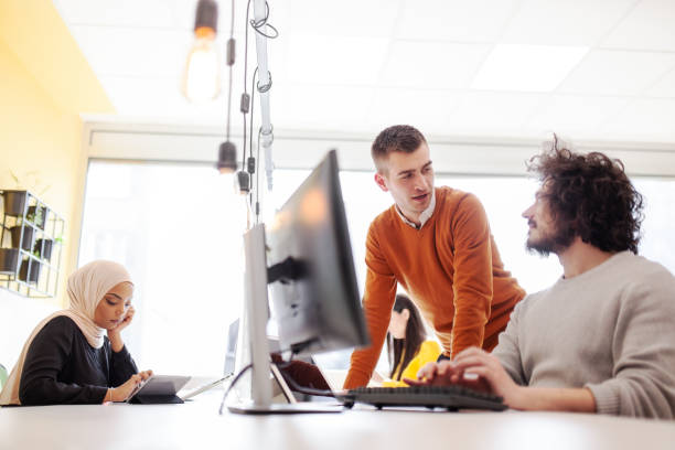 istock Business people having conversation in front of a computer. Modern multiethnic coworking office space. 1344748023