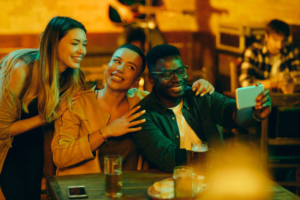 istock Happy friends having fun while taking selfie during their night out in a pub. 1344748082
