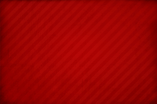 A horizontal vector illustration of textured vibrant red coloured background. Diagonal stripes all over the wallpaper with ample copy space, no people and no text. Can be used as backdrops, wallpaper, laminate textures and designs, greeting cards, posters, banners templates for Christmas or Diwali.