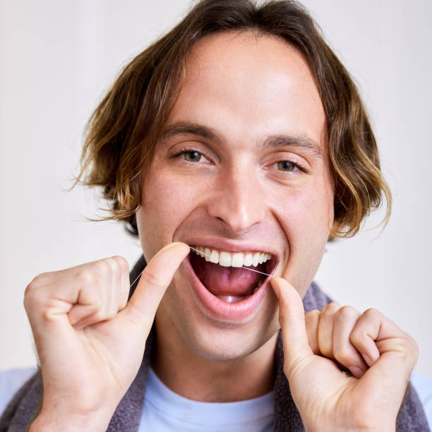 istock Shot of a young man flossing his teeth 1344751203