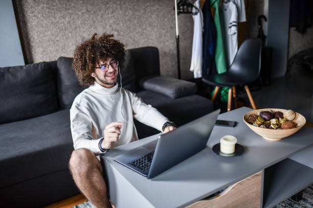 istock Relaxed Male Enjoying Video Conference On Laptop While Sitting On Floor 1344751559