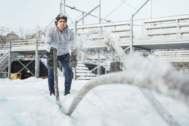 istock Young athlete working out with a battle ropes during snowy winter day. 1344752530