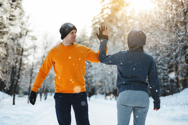 istock Two joggers greeting each other with a high five gesture during winter workout 1344752892