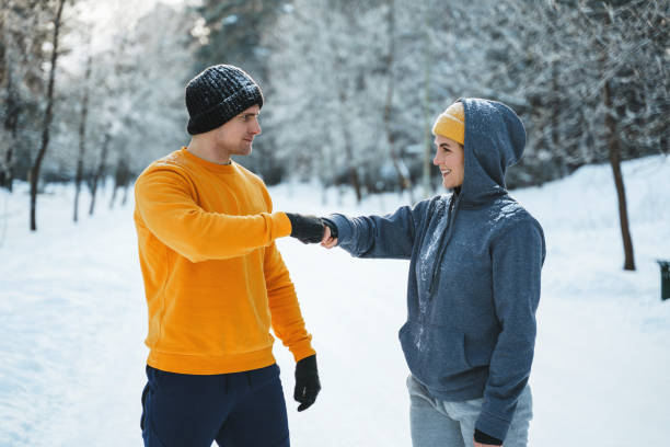 istock Two joggers greeting each other with a fist bump gesture during winter workout 1344752907
