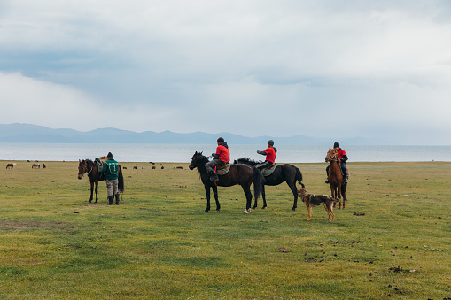 August 27th, 2020 - Group of men having fun playing an old game riding horses in the nomad village by the big lake in Kyrgyzstan