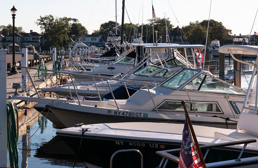 Babylon, New York, USA - 7 September 2021: Side view of many boats tied up and docked in a marina in Babylon Village close up.