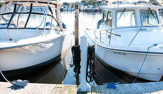 Babylon, New York, USA - 7 September 2021: Close up of two boats that are docked in a marina in Babylon Village New York.
