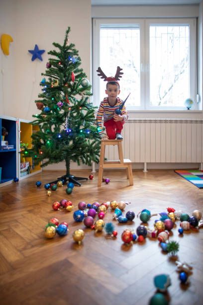 istock Boy putting ornaments on the Christmas tree 1344759219