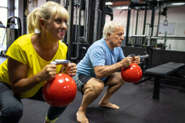 istock Senior couple doing squats with kettlebells in gym 1344760214
