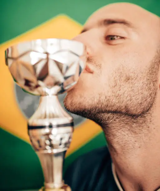 Photo of brazilia man kissing a trophy