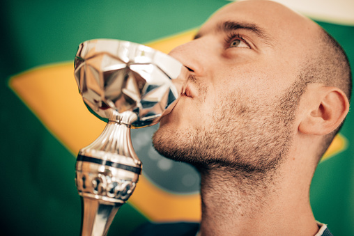 brazilia man kissing a trophy