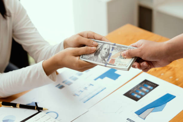 istock Businessman giving or paying money, US dollar bills 1344763368