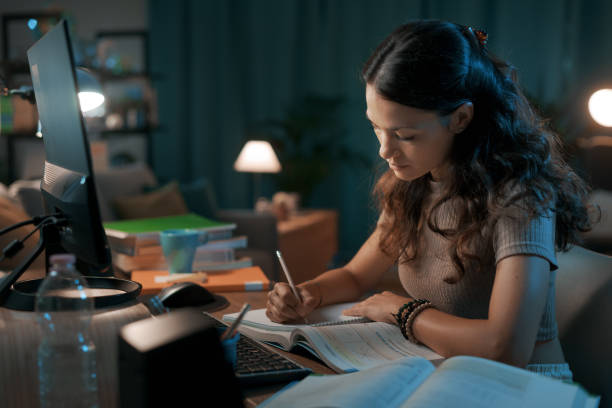 istock Smart young woman studying late at night 1344763443