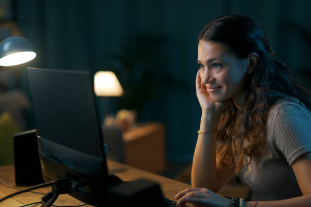 istock Happy young woman connecting online at night 1344763911