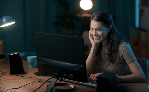istock Happy young woman connecting online at night 1344763955