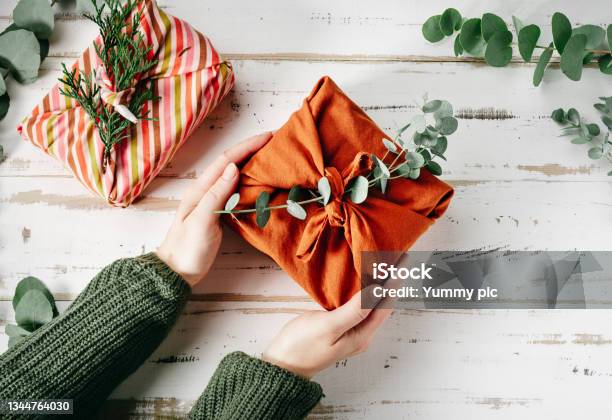 Wrapping A Gift In Eco Friendly Reusable Fabric Package Furoshiki Stock Photo - Download Image Now