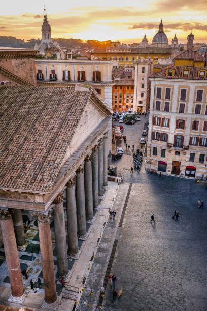 un suggestivo tramonto tra i tetti e le cupole del cuore di roma con il pantheon in primo piano - balcony rome window ornate foto e immagini stock