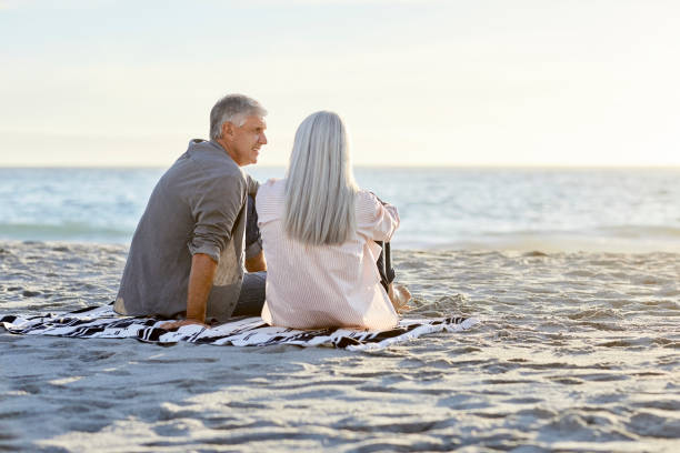 istock Couple sitting on sandy beach during vacation 1344767690