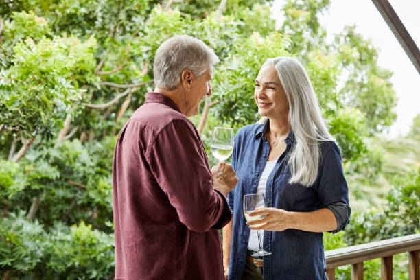 istock Smiling couple drinking wine in balcony 1344767774