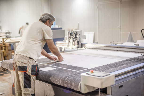 istock Technician works on CNC digital cutter machine for cutting textile 1344767795