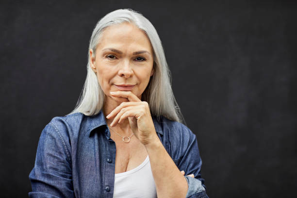 istock Confident mature woman standing against wall 1344767850