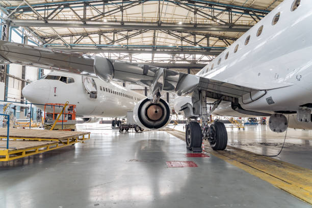 Panoramic view of aerospace hangar with planes Passenger airplane on maintenance repair check in airport hangar. Aircraft concept cladding construction equipment photos stock pictures, royalty-free photos & images