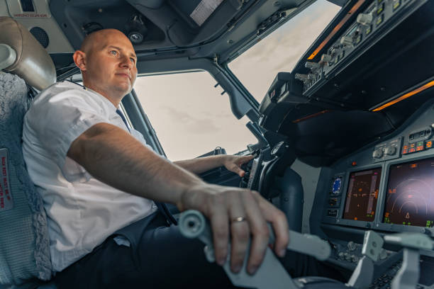 istock Smiling pilot sitting in an airplane cabin flying 1344771317