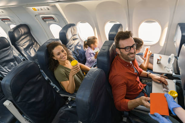 istock Stewardess in protective gloves giving lunch box to a passenger 1344771356