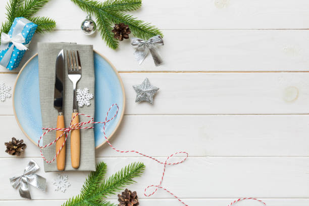 istock Christmas table place setting with christmas decor and plates, kine, fork and spoon. Christmas holiday background. Top view with copy space 1344775730