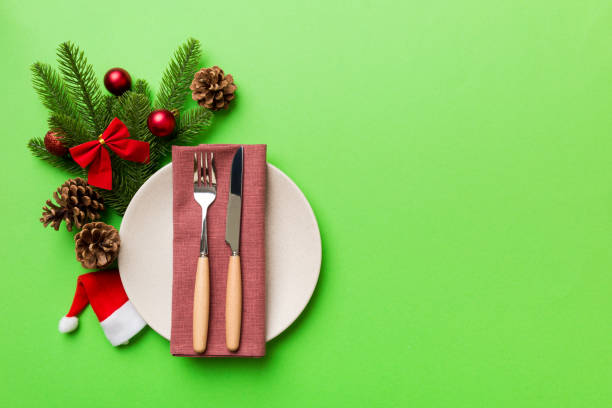 istock Christmas table place setting with christmas decor and plates, kine, fork and spoon. Christmas holiday background. Top view with copy space 1344775736