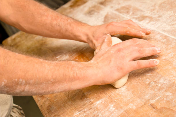 Strong hands of a baker kneading dough