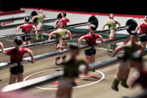 Foosball table game with red and green players