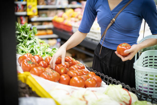istock A young woman selects tomatoes in a supermarket 1344777016