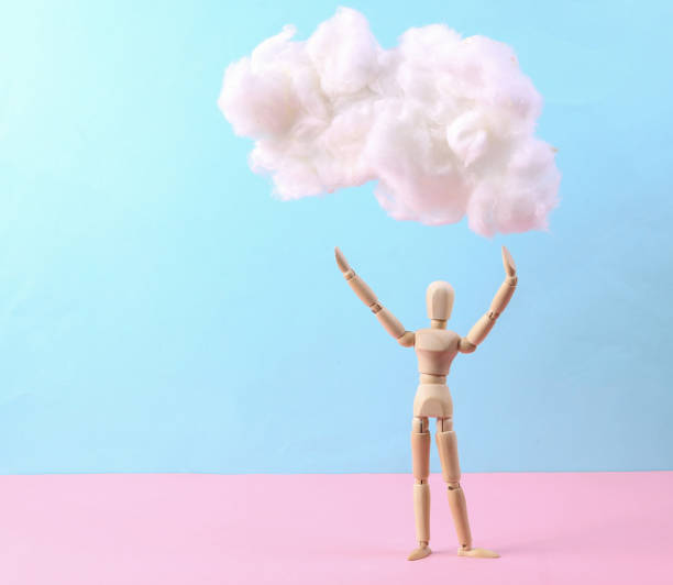 istock Wooden puppet with cloud on pastel pink blue background. Creative idea. Minimal concept. Pastel color trend 1344779395