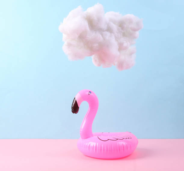 istock Inflatable flamingo with cloud on pastel pink blue background. Creative idea. Summer fun. Minimal concept. Pastel color trend 1344779412