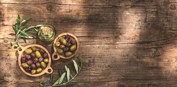 Rustic, village, wooden olive background or internet banner with olive oil and olive branches, sunlight for graphic design and text, copy space, flat lay. Healthy Mediterranean food concept Rustic, village, wooden olive background or internet banner with olive oil and olive branches, sunlight for graphic design and text, copy space, flat lay. Healthy Mediterranean food concept khaki green photos stock pictures, royalty-free photos & images