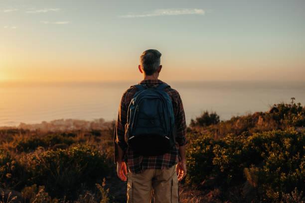 istock Unrecognisable backpacker looking at the view on a hilltop 1344779630