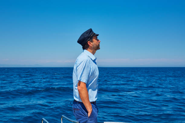 Beard sailor man sailing sea ocean in a boat with captain cap looking horizon