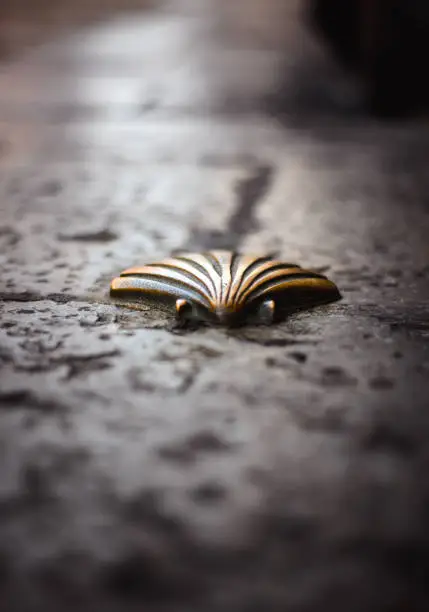 Photo of golden shell on the ground of the camino de santiago