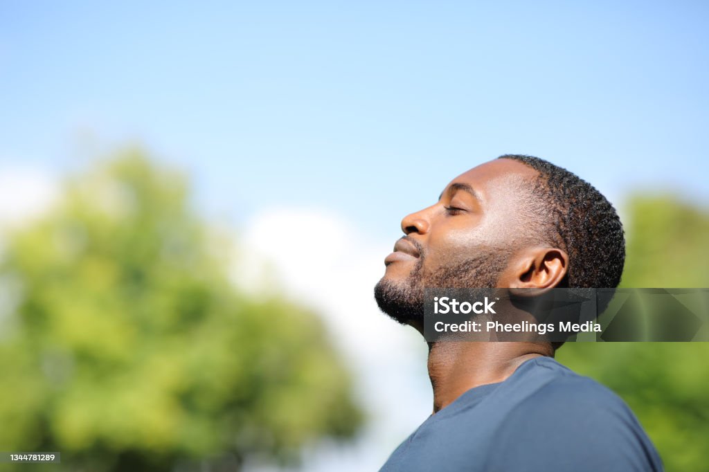 Perfil de un hombre negro respirando aire fresco en la naturaleza - Foto de stock de Hombres libre de derechos