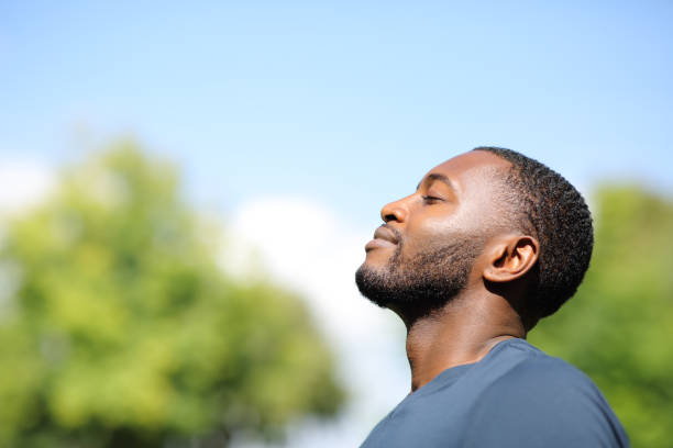 profil czarnego mężczyzny oddychającego świeżym powietrzem w przyrodzie - yoga young adult cheerful happiness zdjęcia i obrazy z banku zdjęć
