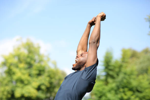 istock Excited black man raising arms in a park 1344781367